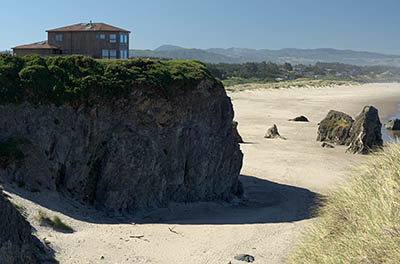 OR: South Coast Region, Coos County, Bandon Area, South Beaches, Face Rock State Wayside, House sits atop sheer rock cliffs with a wide sandy beach below, spotted with large hoodoos [Ask for #274.353.]