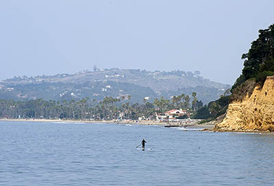 CA: South Coast Region, Santa Barbara County, Pacific Coast Area, City of Santa Barbara, Butterfly Beach, View towards cliffs, with a stand up paddle surfer. [Ask for #271.004.]