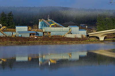 OR: South Coast Region, Coos County, Coast Range, Old Coos Bay Wagon Road, Coos City, A logging mill sits at the far end of the Coos City Bridge, the western terminus of the Old Wagon Road. Reflections on Isthmus Slough at sunrise. [Ask for #276.231.]