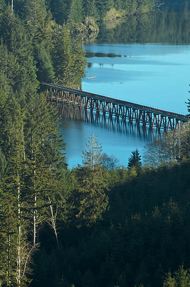 OR: South Coast Region, Douglas County, Pacific Coast, The Lakes Behind the Dunes, Tahkinitch Lake, View over the lake, impounded by the drifting dune sand, with morning fog. A railroad trestle, part of the Coos Bay Rail Link, crosses it. [Ask for #276.453.]