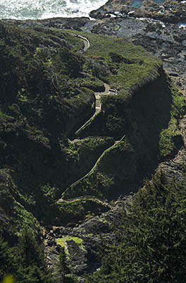 OR: South Coast Region, Lane County, Pacific Coast, Cape Perpetua Area, Cape Perpetua National Scenic Area, Cape Perpetua Overlook, This mountaintop overlook gives views of US 101 hugging the sea cliffs below. View of stair path descending the cliffs at the Visitors Center [Ask for #276.526.]