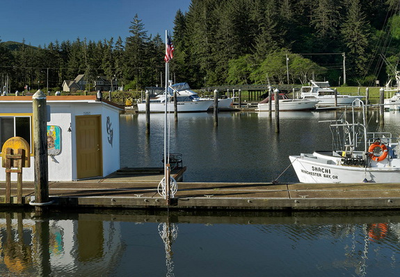 OR: South Coast Region, Douglas County, Pacific Coast, Reedsport Area, Winchester Bay, Sports fishing boats moored at floating dock with harbor master's office and American flag [Ask for #276.709.]