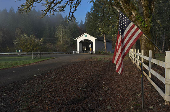 OR: Lane County, South Willamette Valley, Eugene Area, Earnest Covered Bridge. Covered bridge on a well-traveled lane, still carrying traffic. American flag. [Ask for #277.409.]