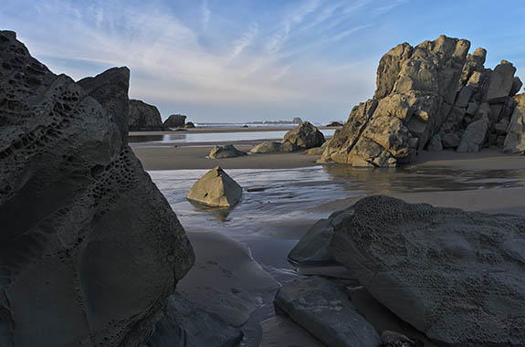 OR: Coos County, Bandon Area, South Beaches, Devils Kitchen State Wayside. Late afternoon beach view towards Haystack Rock on receding tide [Ask for #278.031.]